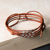 Adjustable wrap leather bracelet in saddle, adorned with handmade ribbed sterling silver tubes and finished with a .925 sterling silver lobster clasp. Perfect for minimalists, can be worn alone or stacked. Adjust by moving the knots to fit your wrist.