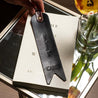 Custom bookmark with unique quote in black leather displayed on top of a book – personalized gift for mom