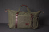 Side leather straps detach to expand the waxed canvas duffle bag allowing for more items.